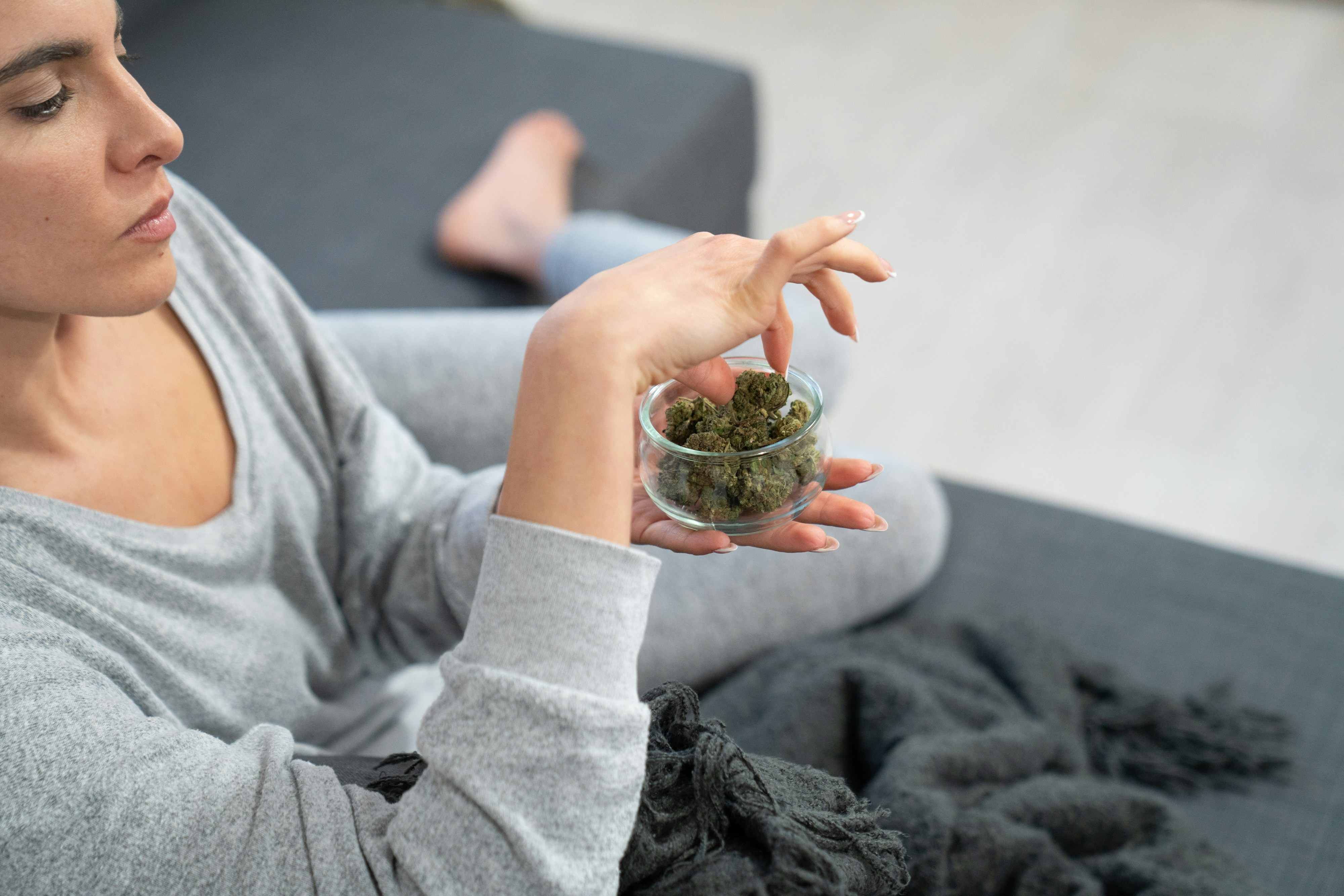A woman handling crushed cannabis leaves.